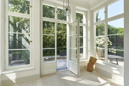 Lichtdurchfluteter Erker mit raumhohen Sprossenfenstern zur Terrasse und Dielenboden