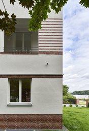 Fassadendetail mit Klinkersockel, Loggia und Ausblick auf das Rheinufer