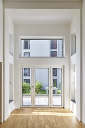 Zweigeschossiger Wohnraum mit Eichenparkett und hoher Fensterfront zur Terrasse
