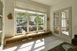 Bibliothek mit integrierter Fenstersitzbank aus Holz, Sprossenfenstern und Gartenblick