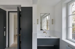 Badezimmer mit dunkelblauem Waschtisch, Marmorplatte, Messingarmatur und Sprossenfenster