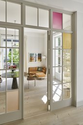 Verglaste Flügeltür mit farbigen Glaseinsätzen und Sichtachse in das Esszimmer