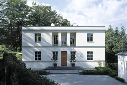 Symmetrische Eingangsfassade der zweigeschossigen Villa mit Freitreppe und Pfeilerloggia