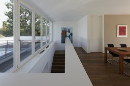Lichtdurchfluteter Essbereich im Obergeschoss mit langem Fensterband und offenem Treppenabgang