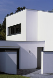 Eingangsbereich und Garagenzufahrt mit geometrisch gestaffelten weißen Wandscheiben