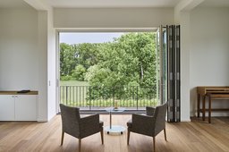 Wohnraum mit Parkettboden und geöffneter Glasfaltwand zum Balkon mit Blick auf den Rhein