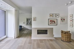 Offener Wohnbereich mit integriertem Kamin und hellem Holzdielenboden