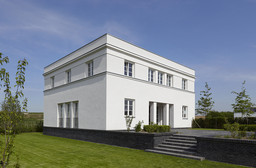Gartenansicht des kubischen Baukörpers mit Klinkersockel und gemauerter Außentreppe