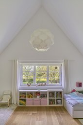 Kinderzimmer im Dachgeschoss mit giebelhoher Decke, dreiteiligem Sprossenfenster und Eichendielen
