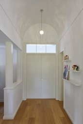 Eingang mit weißer Tonnendecke, Flügeltür mit Oberlicht und Eichendielen