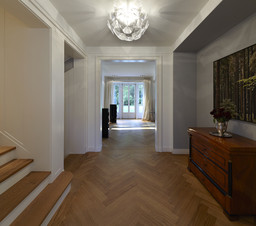 Eingangshalle mit Fischgrätparkett und Sichtachse durch das Haus zum Garten