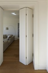 Weiße Faltflügeltür als Raumübergang in den Wohnbereich mit Eichendielen