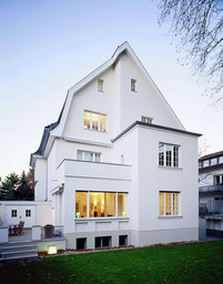 Gartenfassade der Stadtvilla mit kubischem Erweiterungsanbau, Panoramafenster und Terrasse