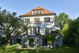 Gartenfassade mit Sockelgeschoss, feingliedrigen Sprossenfenstern und klassischem Walmdach