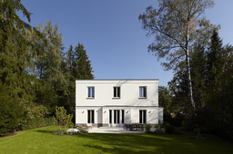 Symmetrische Gartenfassade mit Säulenportal und Terrasse im Sonnenlicht