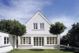 Symmetrische Gartenfassade mit Spitzgiebel und geschlossener bodentiefer Verglasung