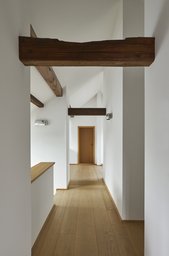 Heller Dachgeschossflur mit freiliegenden Holzbalken und hellem Dielenboden