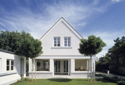 Symmetrische Gartenfassade mit Spitzgiebel und geöffneten Faltschiebeelementen zum Garten