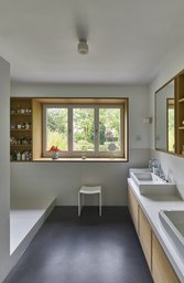Badezimmer mit Eichenholz-Einbaumöbeln, Waschtisch und Ausblick in den Garten
