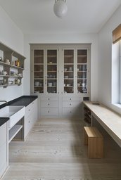 Nebenküche mit maßgefertigtem Vitrinenschrank, Keramikspülbecken und durchgehender Holzarbeitsfläche