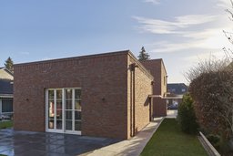 Eingeschossiges Ateliergebäude mit Klinkerfassade, Steinterrasse und bodentiefen Fenstern