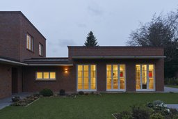 Eingeschossiger Klinkerflügel mit drei bodentiefen Fenstertüren zum Garten