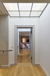 Diele im Obergeschoss mit gerasterter Lichtdecke und Blickachse zum Wohnraum