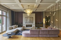 Wohnraum mit repräsentativer Kassettendecke, zentralem Kamin und moderner Lounge-Möblierung
