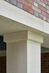 Detail eines profilierten Sandsteinpfeilers mit Kapitell unter Klinkermauerwerk