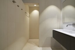 Minimalistisches Badezimmer mit Waschtisch, Wandarmatur und begehbarer Duschnische