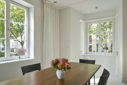 Lichtdurchfluteter Essbereich mit Holztisch und tiefen Fensternischen im Erker