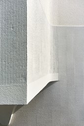 Fassadendetail mit fein strukturiertem Kammputz und präzise ausgeführten Putzkanten