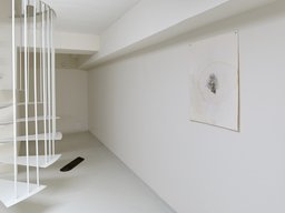 Filigrane weiße Spindeltreppe mit vertikalem Stabgeländer im Ausstellungsraum