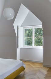 Schlafzimmer im Dachgeschoss mit polygonaler Gaubennische, Innenklappläden und Fischgrätparkett