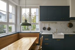 Maßgefertigte Wohnküche mit integrierter Holz-Eckbank, Marmorarbeitsplatte und Sprossenfenstern