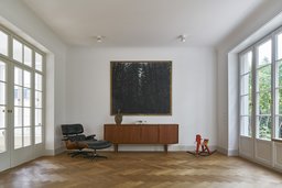 Wohnzimmer mit Fischgrätparkett, Sprossentüren und klassischem Designmobiliar