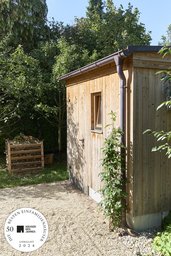 Geräteschuppen mit Holzfassade, kleinem Fenster und Pultdach im Garten