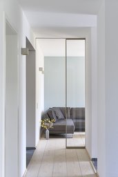 Flur mit raumhoher Glastür und Blick in das Wohnzimmer