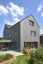 Gartenansicht mit Sonnenterrasse, Essplatz und großflächigen Fenstertüren Erdgeschoss