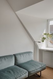 Wohnbereich unter der Dachschräge mit Gaubennische, Samtsofa und Parkettboden
