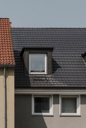 Dachgaube mit dunkler Zinkverkleidung auf ziegelgedecktem Satteldach