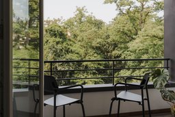 Dachloggia mit schwarzem Metallgeländer und weitem Ausblick in Baumkronen