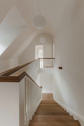 Obere Diele mit Galerie, Holztreppe und weißem Geländer im Dachgeschoss