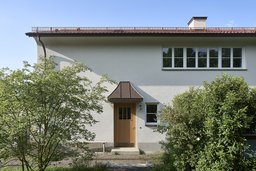 Putzfassade mit Haustür aus Eiche und Vordach aus Kupfer