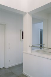 Heller Galerieflur im Obergeschoss mit Luftraum, quadratischer Stütze und Edelstahlgeländer