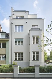 Straßenfassade des mehrgeschossigen Wohnhauses mit Erker und Staffelgeschoss